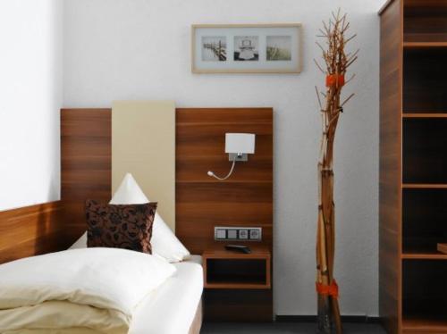 ein Schlafzimmer mit einem Bett mit einem Kopfteil aus Holz in der Unterkunft Hotel Schützenhof SPA GARDEN in Bürstadt