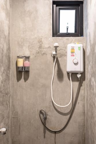 a bathroom with a shower with a soap dispenser at The Cocoon Hostel in Bangkok