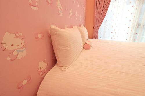 a bedroom with a bed with a hello kitty wall at Romantic B&B in Hualien City