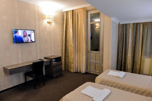 a hotel room with two beds and a desk at Hotel Old Town in Kutaisi
