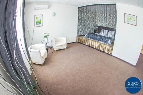 a hospital room with a bed and chairs and a mirror at Aster Hotel-ZURO in Ulyanovsk