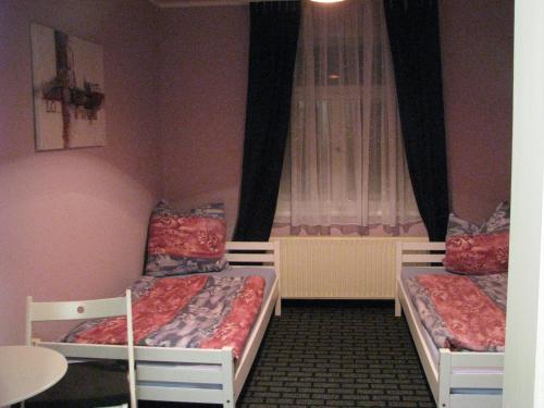 2 camas en una habitación pequeña con ventana en Ferienwohnung Charlett, en Dresden