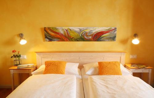 a bedroom with two beds and a painting on the wall at Weinhof am Nussbaum in Willanzheim