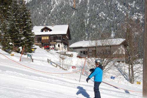 a person riding a snowboard down a snow covered slope at Ferienwohnung Pension Tirol in Bichlbach
