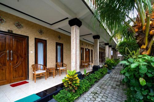 a building with a porch with chairs and a wooden door at Megacahya Bungalow in Nusa Lembongan