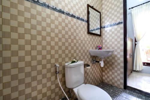 a bathroom with a toilet and a sink at Megacahya Bungalow in Nusa Lembongan