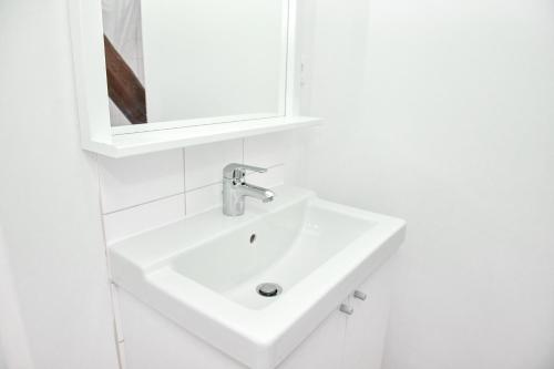 a white bathroom with a sink and a mirror at Townhouse Duderstadt in Duderstadt