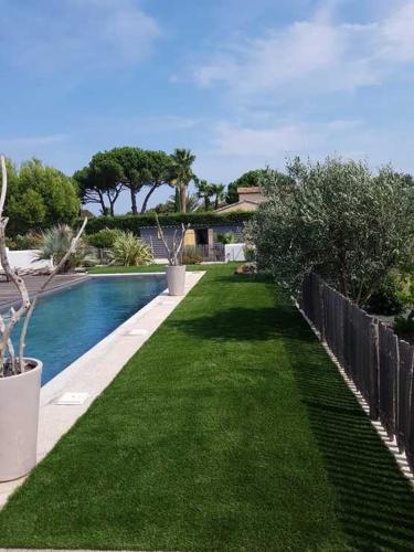 une cour avec une clôture et une piscine dans l'établissement Les Lodges Saint Pierre, au Cap d'Agde