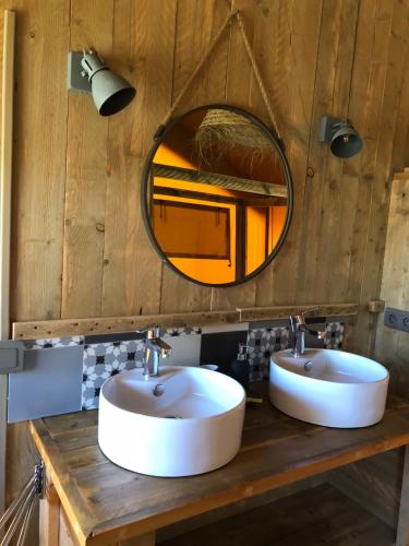 une salle de bain avec deux lavabos et un miroir dans l'établissement Les Lodges Saint Pierre, au Cap d'Agde