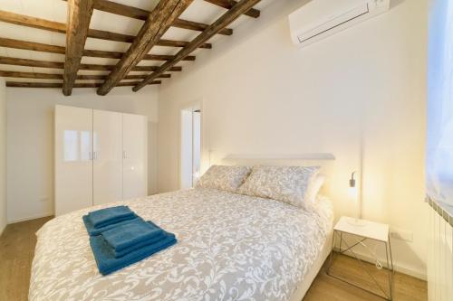 Un dormitorio con una cama con una toalla azul. en New apartment in Murano the amazing glass island, en Murano