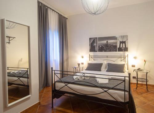 una camera con letto e specchio di Holiday Rooms Portale Pirrera a Modica