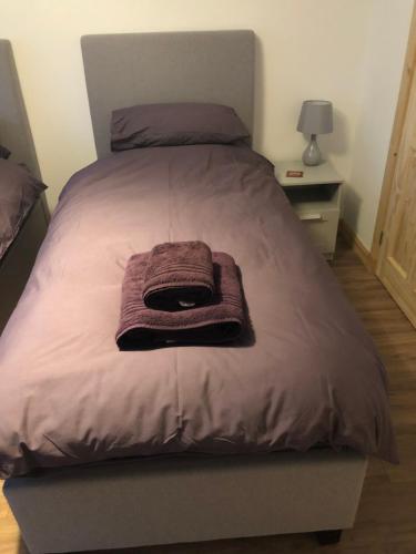 uma cama com um cobertor roxo em cima em Edindoune em Strathcarron