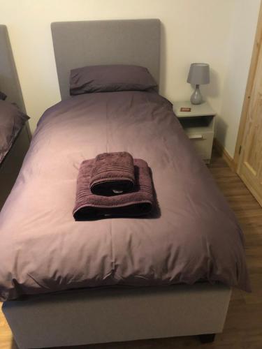 a bed with a purple blanket on top of it at Edindoune in Strathcarron