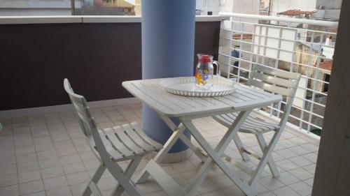 a white table and two chairs on a balcony at "La casa di Mariagrazia" Appartamento 4 locali in Sammichele di Bari