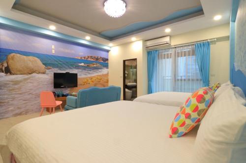 a hotel room with two beds and a tv at Romantic B&B in Hualien City