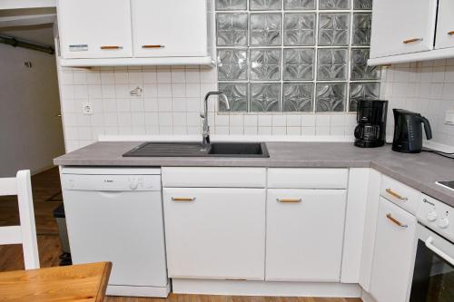a kitchen with white cabinets and a sink at Townhouse Duderstadt in Duderstadt