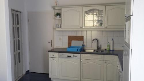 a kitchen with white cabinets and a sink at Ferienwohnung "An der Würschnitz" in Chemnitz