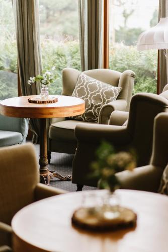 a living room with chairs and a table and a window at Hotel Rezydencja Solei in Poznań