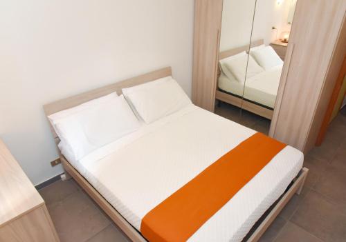 a small bedroom with a bed and a mirror at Appartamento sulla spiaggia in Gallipoli