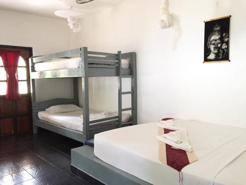 ランタ島にあるPapillon Bungalowsの二段ベッド2台とソファが備わる客室です。