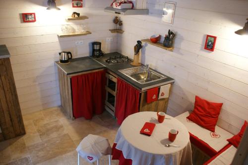 ラ・トゥール・ドーヴェルニュにあるLe p'tit gîte de Chometのキッチン(テーブル、シンク、コンロ付)