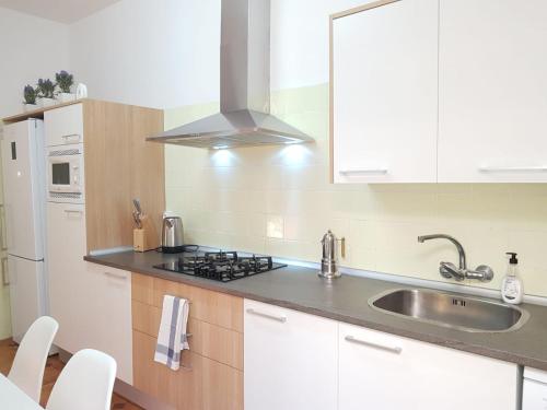 a white kitchen with a sink and a stove at Casual House Valencia in Valencia