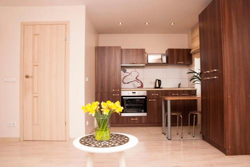 ヴィリニュスにあるEVArent Apartament Free parkingのテーブルの上に黄色い花瓶を飾ったキッチン