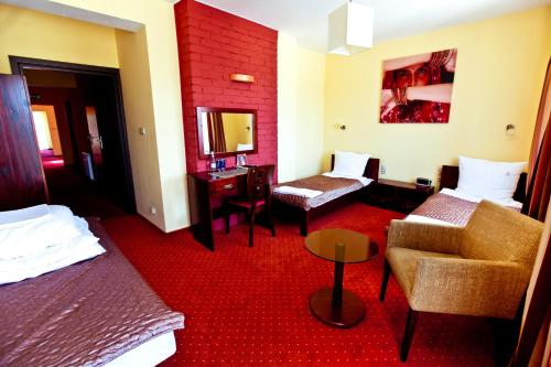 a hotel room with two beds and a chair at Dwa Bratanki in Rzeszów