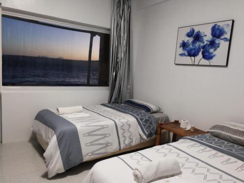 two beds in a room with a window at Jelly Sea Resort in Siquijor