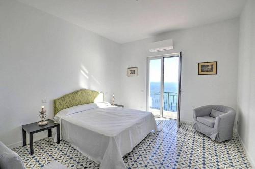 - une chambre avec un lit, une chaise et une fenêtre dans l'établissement CASA LONE, à Amalfi