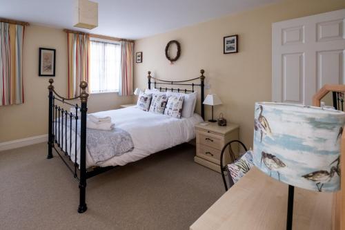 um quarto com uma cama e uma cadeira em Ogilvie Lodge Apartment em Thorpeness