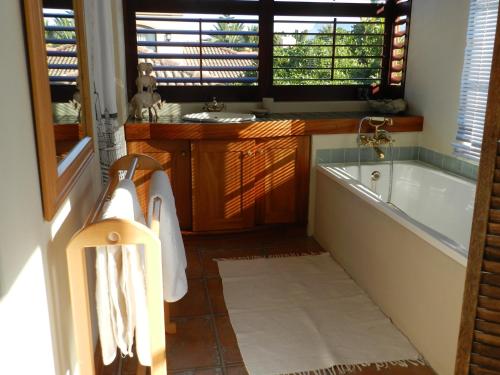 a bathroom with a bath tub and a sink at Sunset at Diluta in Cape Town