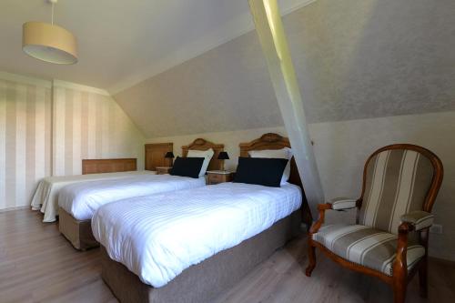 2 letti in camera d'albergo con sedia di Gîte Aux Deux Clochers a Zimmersheim