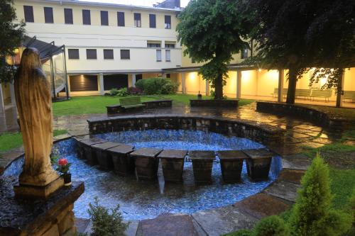 a pool in a yard with a statue in front of a building at Casa per ferie Al Centro in Belluno