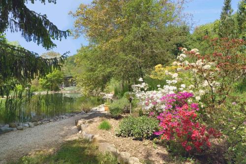 a garden with flowers next to a body of water at Bergwerksilo Herznach in Herznach