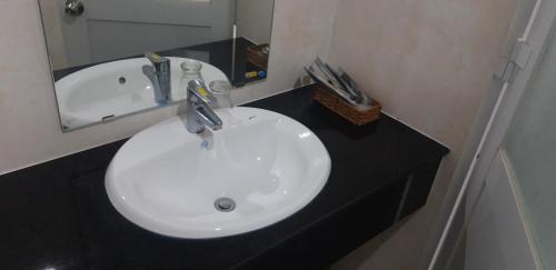 a white sink in a bathroom with a mirror at Sao Kim in Cà Mau