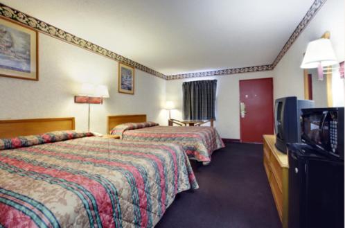 a hotel room with two beds and a flat screen tv at Americas Best Value Inn & Suites Macon in Macon