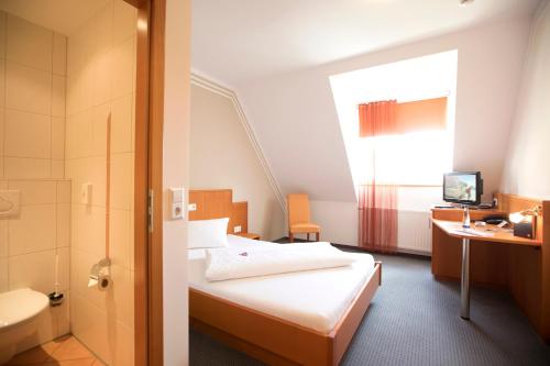 ヴァイセンホルンにあるNeumaiers Hirsch -Gasthof und Landhotelのベッドとバスルーム付きのホテルルームです。