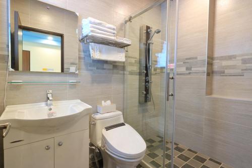 a bathroom with a toilet and a sink and a shower at Romantic B&B in Hualien City