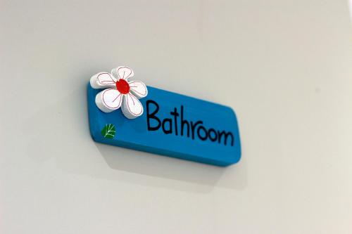 a blue sign with a white flower on it at Lima Sol House in Limassol