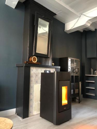a room with a fireplace with a mirror on the wall at Appartement OKP15 in Middelburg