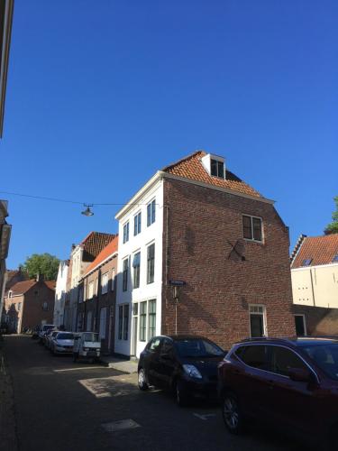 un edificio de ladrillo con coches aparcados en una calle en Appartement OKP15, en Middelburg