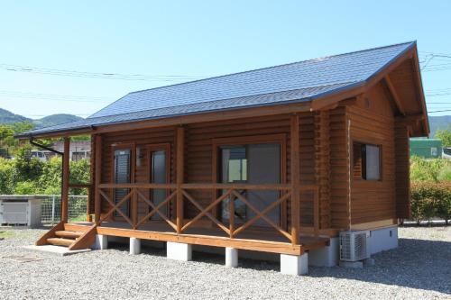 a wooden cabin with a black roof at 美濃田の淵キャンプ村 in Higashimiyoshi