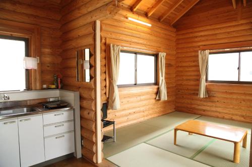 a kitchen with wooden walls and windows in a cabin at 美濃田の淵キャンプ村 in Higashimiyoshi