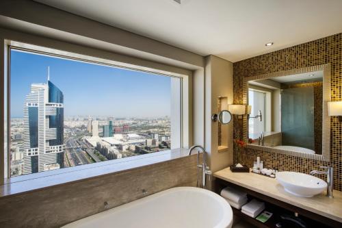 a bathroom with a large window with a view of the city at The Tower Plaza Hotel Dubai in Dubai