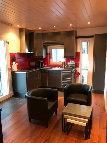 a kitchen with black chairs and a table in a room at Les Mouresses in Savièse