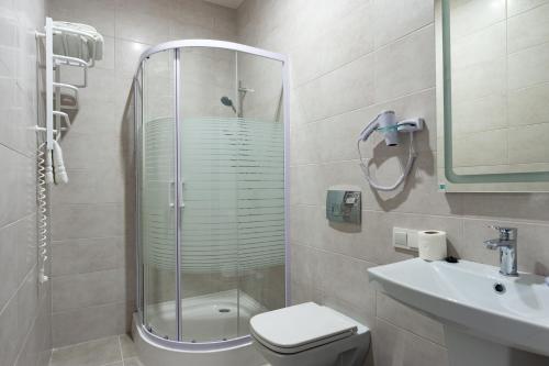 a bathroom with a shower and a toilet and a sink at Hotel Voskresensky in Sumy