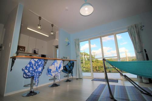 a room with two chairs and a hammock at Amami Mahalo in Tatsugo