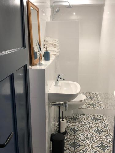a white bathroom with a sink and a toilet at Appartement OKP15 in Middelburg