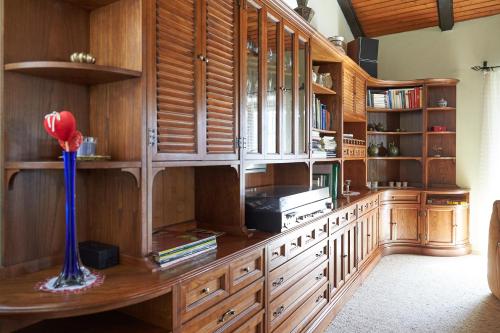 une bibliothèque avec des armoires en bois et un vase avec une fleur dans l'établissement Semmering Villa Sonnenschein, à Semmering